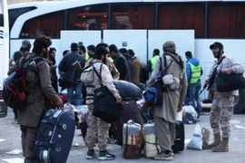 Các tay súng đối lập cùng gia đình sơ tán khỏi Đông Qalamun, Đông Bắc Damascus ngày 23/4. (Nguồn: AFP/TTXVN)