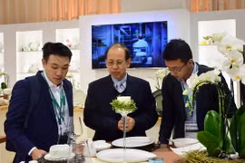 Ông Lý Ngọc Minh (đứng giữa) giới thiệu sản phẩm gốm sứ Minh Long I tại Triển lãm Ambiente - hội chợ thương mại về ngành sứ lớn nhất châu Âu. (Ảnh: TTXVN phát)