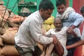 Chuyển một nạn nhân bị thương ra khỏi ngôi nhà bị sập do bão cát và mưa dông ở Agra, bang Uttar Pradesh. (Nguồn: AFP/TTXVN)