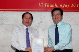 Ông Mai Văn Chính, Phó Trưởng ban Tổ chức Trung ương, trao quyết định của Ban Bí thư về công tác cán bộ cho ông Lê Tiến Châu. (Ảnh: Duy Khương/TTXVN)