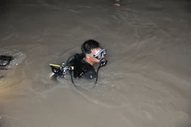 Thợ lặn chuyên nghiệp được điều động tìm kiếm người mất tích trong đêm. (Ảnh: Sỹ Tuyên/TTXVN)