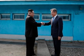 Tổng thống Hàn Quốc Moon Jae-in (phải) và nhà lãnh đạo Triều Tiên Kim Jong-un bắt tay hữu nghị tại đường phân định ranh giới hai miền ở làng đình chiến Panmunjom ngày 27/4. (Nguồn: Yonhap/TTXVN)