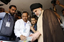 Thủ lĩnh cộng đồng người Hồi giáo dòng Shiite Moqtada al-Sadr (giữa, phải) bỏ phiếu tại điểm bầu cử ở thành phố Najaf ngày. (Nguồn: AFP/TTXVN)