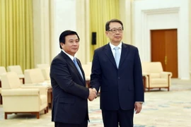 Bí thư Trung ương Đảng Nguyễn Xuân Thắng và ông Trần Hy bắt tay thân mật. (Ảnh: Lương Tuấn/Vietnam+)