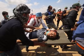 Chuyển người biểu tình Palestine bị thương sau các cuộc đụng độ với binh sỹ Israel tại khu vực biên giới Dải Gaza với Israel. (Nguồn: AFP/TTXVN)