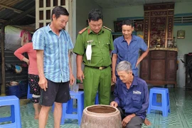 Ông Nguyễn Văn Chiến (ngồi) trình báo với cơ quan chức năng khi bắt được tê tê. (Ảnh: Thanh Liêm/TTXVN)