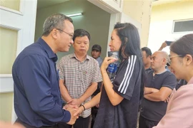 Ông Khuất Việt Hùng (áo đen), Phó Chủ tịch Chuyên trách Ủy ban An toàn Giao thông Quốc gia cùng ông Nguyễn Hữu Quế, Phó Chủ tịch Ủy ban Nhân dân tỉnh Gia Lai đến thăm hỏi, động viên vợ cầu thủ Paollo Madeira Oliveira. Ảnh: Quang Thái/TTXVN)