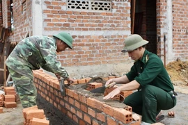 Các chiến sỹ Đồn Biên phòng Ia R’Vê, huyện Ea Súp, tỉnh Đắk Lắk góp ngày công xây dựng nhà ở cho hộ nghèo. (Ảnh: Dương Giang/TTXVN)