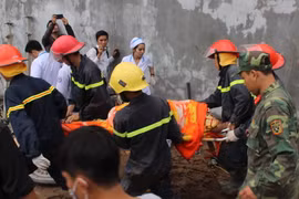 Lực lượng cứu hộ đưa nạn nhân ra ngoài. (Ảnh: Nguyên Lý/TTXVN)
