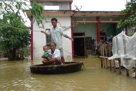Người dân tại các xã vùng Nam Thị xã Ba Đồn, Quảng Bình phải dùng thúng để di chuyển trong vùng ngập lụt. (Ảnh: Đức Thọ/TTXVN)