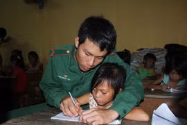 Dù là lớp học phổ cập xóa mù chữ, nhưng các em nhỏ luôn được những thầy giáo mang quân hàm xanh ở Đồn biên phòng Tuyên Bình chỉ bảo tận tình. (Ảnh: Trường Giang/TTXVN)