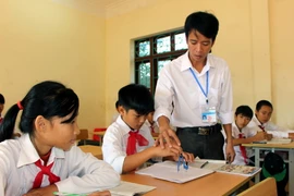 Thầy giáo Nguyễn Thành Tân hướng dẫn bài cho học sinh của mình trong giờ lên lớp. (Ảnh: Văn Đức/TTXVN)