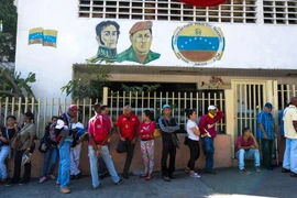 Người dân Venezuela xếp hàng chờ đổi tiền bên ngoài ngân hàng trung ương ở Caracas ngày 16/12. (Nguồn: AFP/TTXVN)