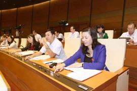 Đại biểu Quốc hội tỉnh Bắc Giang biểu quyết thông qua Luật tín ngưỡng, tôn giáo. (Ảnh: Phương Hoa/TTXVN)