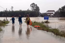 Lực lượng công an xã Hành Minh, huyện Nghĩa Hành túc trực kiểm tra các đường giao thông bị ngập lũ không cho người dân tự ý lưu thông. (Ảnh: Trần Lê Lâm/TTXVN)