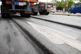 Nhiều tuyến Quốc lộ bị lún nền đường in hằn vệt bánh xe. (Ảnh: TTXVN)