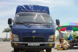 Xe quá tải đang được tiến hành cân bằng trạm cân di động. (Ảnh: Việt Hùng/Vietnam+)