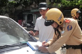 Lực lượng Cảnh sát giao thông tiến hành xử phạt xe taxi vi phạm. (Ảnh: Việt Hùng/Vietnam+)