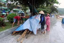 Người dân trên bãi biển Đồ Sơn chằng giữ đồ phòng chống bão. (Ảnh: Hoàng Ngọc/ TTXVN)