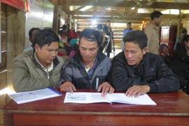 Người dân xã Măng Cành, huyện Kon Plông hiểu rõ tình hình động đất và biện pháp phòng tránh thiệt hại thông qua tài liệu tuyên truyền. (Ảnh: Dư Toán/TTXVN)