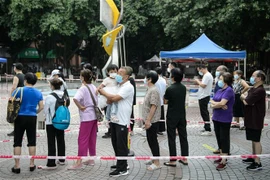 Người dân xếp hàng chờ xét nghiệm COVID-19 tại Quảng Đông, Trung Quốc. (Ảnh: AFP/TTXVN)