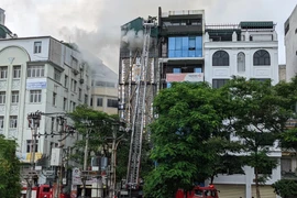 Cảnh sát phòng cháy chữa cháy và cứu nạn, cứu hộ, Công an thành phố Hà Nội đã dùng xe thang đưa lực lượng chữa cháy lên khu vực tầng thượng của ngôi nhà. (Ảnh: TTXVN phát)