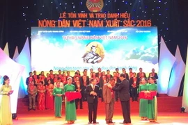 Chủ tịch nước Trần Đại Quang trao danh hiệu cho các nông dân xuất sắc. (Ảnh: Thanh Tâm/Vietnam+)