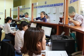 Người dân đến làm thủ tục tại bộ phận một cửa Văn phòng Đăng ký đất đai Hà Nội. (Ảnh: Đỗ Phương Anh/TTXVN)