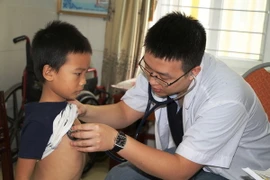 Bác sỹ Bệnh viện Việt Đức khám sàng lọc bệnh tim cho trẻ dưới 16 tuổi. (Ảnh: Hoàng Ngà/TTXVN)