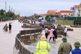 Lực lượng chức năng tìm cách thông đường trên tuyến Quốc lộ 1A đoạn qua thị xã Ba Đồn. (Ảnh: Đức Thọ/TTXVN)