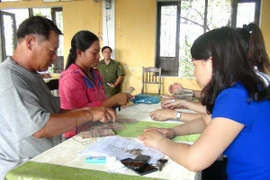 Người dân xã Lộc Điền nhận tiền bồi thường. (Ảnh: Tường Vi/TTXVN)
