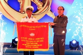 Chủ tịch Ủy ban Trung ương MTTQ Việt Nam Nguyễn Thiện Nhân trao tặng bức trướng tại Chương trình giao lưu. (Ảnh: Nguyễn Dân/TTXVN) 