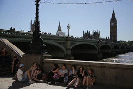 Người dân Anh nghỉ ngơi bên bờ Sông Thames ở trung tâm thành phố London. (Nguồn: AFP/TTXVN)