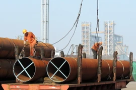 Công nhân vận chuyển thép tại một cảng ở thành phố Liên vận cảng, tỉnh Giang Tô, Trung Quốc. (Nguồn: AFP/TTXVN)