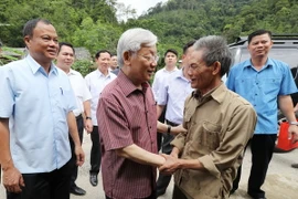 Tổng Bí thư Nguyễn Phú Trọng đến thăm, tặng quà ông Nông Đức Phấn, hộ cận nghèo, dân tộc Tày ở thôn Nà Loạn, xã Sĩ Bình, huyện Bạch Thông. (Ảnh: Trí Dũng/TTXVN)