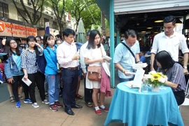 Đông đảo độc giả đến giao lưu, xin chữ ký nhà văn Nguyễn Ngọc Tư tại đường sách Nguyễn Văn Bình. (Ảnh: TTXVN)