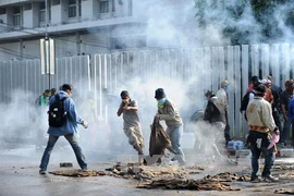 Người biểu tình chống chính phủ xung đột với cảnh sát chống bạo động ở Bangkok. (Nguồn: THX/TTXVN)