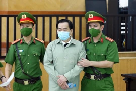 Lực lượng chức năng dẫn giải bị cáo Phan Văn Anh Vũ đến phiên tòa xét xử. (Ảnh: Phạm Kiên/TTXVN)