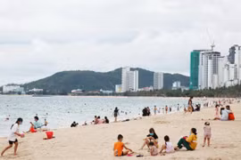 Bãi biển Nha Trang đã nhộn nhịp trở lại trong ngày đầu tiên cho phép tắm biển. (Ảnh: Tiên Minh/TTXVN)