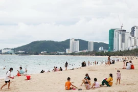 Bãi biển Nha Trang đã nhộn nhịp trở lại trong ngày đầu tiên cho phép tắm biển. (Ảnh: Tiên Minh/TTXVN)