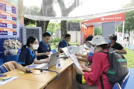 Doanh nghiệp du lịch tư vấn sản phẩm tour quốc tế cho du khách tham quan Hội chợ. (Ảnh: Mỹ Phương/TTXVN)