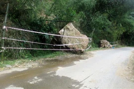 Đá rơi từ trên núi xuống tuyến đường tỉnh 523D. (Ảnh: Nguyễn Nam/TTXVN)