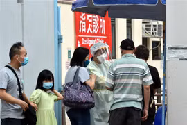 Nhân viên y tế hướng dẫn người dân tại một điểm xét nghiệm COVID-19 ở Hong Kong, Trung Quốc. (Ảnh: THX/TTXVN)