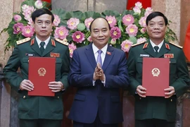 Chủ tịch nước Nguyễn Xuân Phúc, Thống lĩnh các lực lượng vũ trang nhân dân, Chủ tịch Hội đồng Quốc phòng và An ninh, trao Quyết định thăng quân hàm từ Trung tướng lên Thượng tướng đối với các đồng chí Ngô Minh Tiến (bên phải) và Lương Đình Hồng (bên trái)