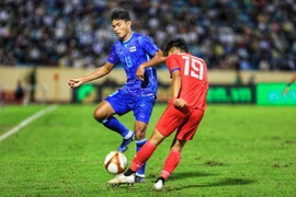 Cầu thủ U23 Thái Lan Teerasak Poeiphimai (số 13) cản đường lên bóng của cầu thủU23 Lào. (Ảnh: Tuấn Anh/TTXVN)