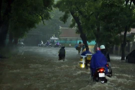 Các phương tiện di chuyển khó khăn trên đường Mai Xuân Thưởng sau cơn mưa lớn tại Hà Nội. (Ảnh: Thống Nhất/TTXVN)