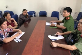 Cô Lê Thị Chiều (áo hồng) tại cơ quan Công an. (Ảnh: TTXVN phát)