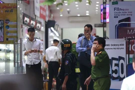 Cảnh sát kiểm tra, khám xét tại cửa hàng điện thoại Nhật Cường mobile ở 33 Lý Quốc Sư, Hà Nội. (Ảnh: Doãn Tấn/TTXVN)