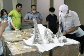 Đục các khối thạch cao ra, lực lượng chức năng phát hiện bên trong có chứa 55 khúc sừng tê giác, tổng trọng lượng 125,15kg. (Ảnh: TTXVN phát)