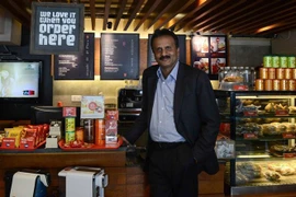 Ông trùm càphê V.G. Siddhartha chụp ảnh lưu niệm tại một cửa hàng của ông ở Ahmedabad, Ấn Độ. (Ảnh: AFP/TTXVN)